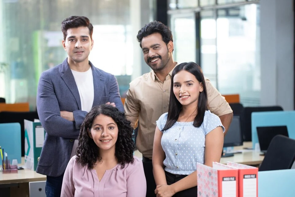 A group of corporate employess standing with confidence, depicting the talent pool in Salesforce consultants in India